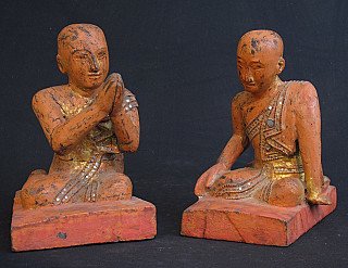 Set houten monniksbeelden uit Burma, zittend op rode sokkel, vooraanzicht met namaskara