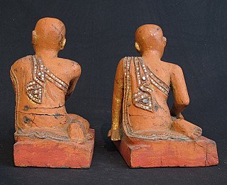 Achteraanzicht van de twee houten monniksbeelden met beschilderde rug en slijtage op de sokkels