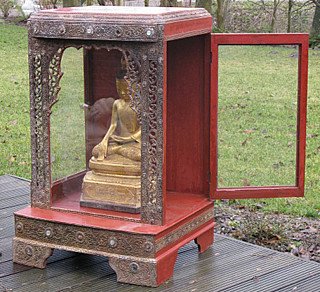 Birmanischer Holzschrein mit geöffneter Seitentür und sitzender Statue im Inneren