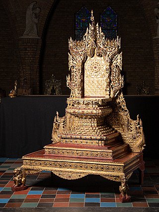 Antique Burmese Mandalay wooden throne, three-quarter view showing the empty niche and decorated back panel