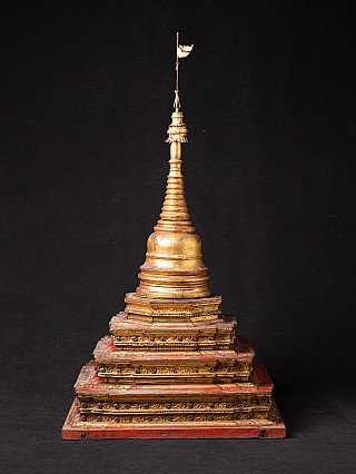 Hölzerne burmesische Stupa (19. Jh.) mit schlankem Spitzaufsatz und rotem Stufensockel, frontal