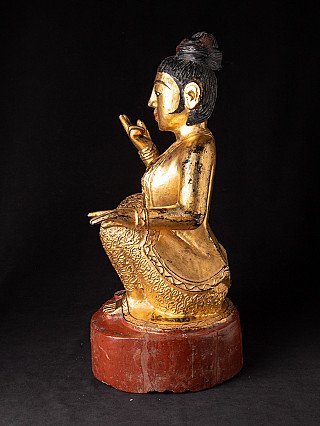 Burmesische Nat-Statue aus Holz in Sitzhaltung, Seitenansicht mit Handgeste und rotem Sockel