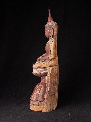 Wooden Burmese Buddha statue, left side profile showing the tall finial