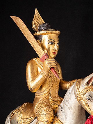 Detail der Nat-Figur mit Schwert und vergoldeter Kleidung, schräg von der Seite
