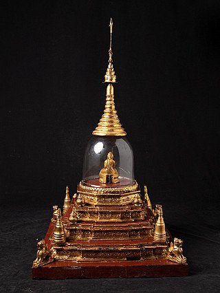 Antieke Birmese stupa op rood houten voetstuk, achteraanzicht met glazen stolp