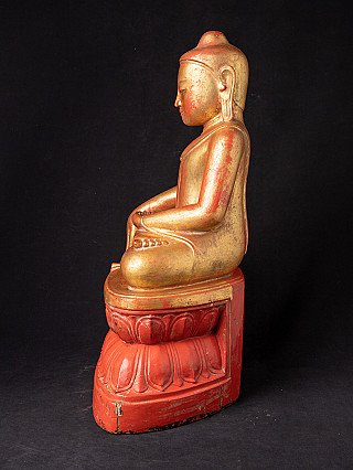 Burmese wooden Buddha statue seated, left side profile with red and gold surface
