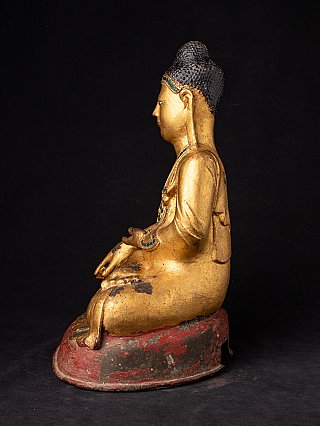 Seated Burmese bronze Buddha statue, left side profile with red base
