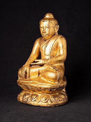 Burmese wooden Buddha statue with gilded surface, seated on lotus base, three-quarter view