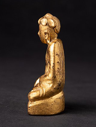 Antique Burmese wooden Buddha statue seated, left side profile with elongated earlobe