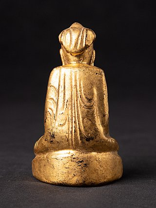 Burmese wooden Buddha statue seated, rear view showing robe folds down the back