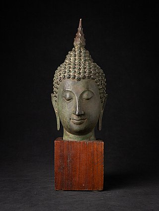 Thai bronze Buddha head on wooden base, full front view with flame finial