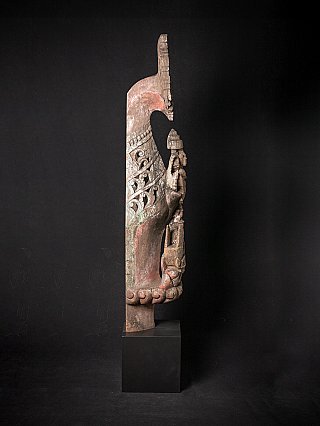 Burmese wooden temple panel in side profile, showing a seated figure and scalloped edge