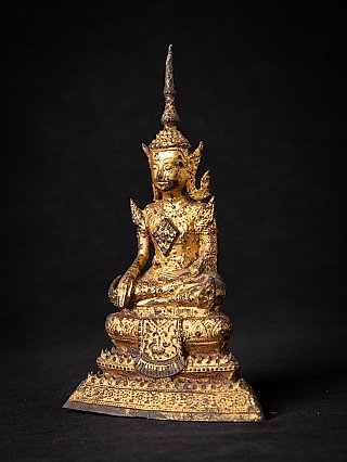 Bronze Thai Buddha statue seated, three-quarter view highlighting the patterned base