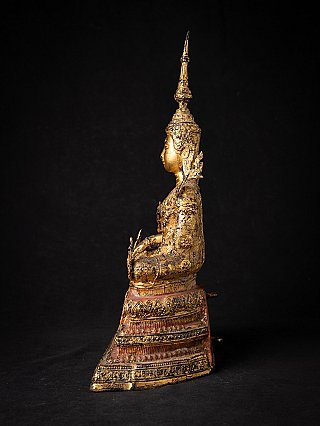 Thai bronze crowned Buddha statue, left side profile view with seated posture and stepped base