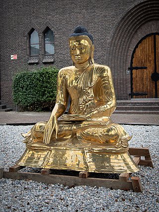 Burmese bronze Buddha statue, seated, three-quarter left view on wooden support frame