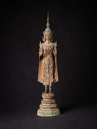 Thai bronze Buddha statue standing on a tiered base, full-front view with Abhaya mudra