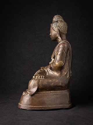 Burmese bronze Buddha statue, right side profile with elongated ear and stepped base
