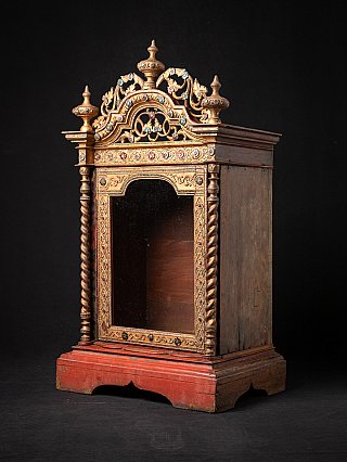 Antique wooden Burmese temple shrine, three-quarter view with red base and open niche