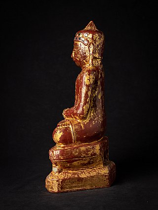 Burmese wooden Buddha statue seated, left side profile view with stepped base