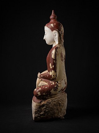 Burmese marble Buddha statue, left side profile view with red painted surface and rough stone base