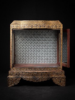 Burmese wooden temple shrine with the right door open, showing the patterned metal interior