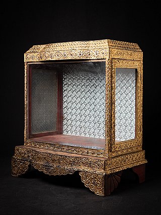 Wooden Burmese temple shrine in three-quarter view, showing gilt carvings and glass panels