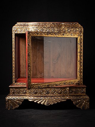 Burmese wooden temple shrine with gilded frame, glass door partly open in front view