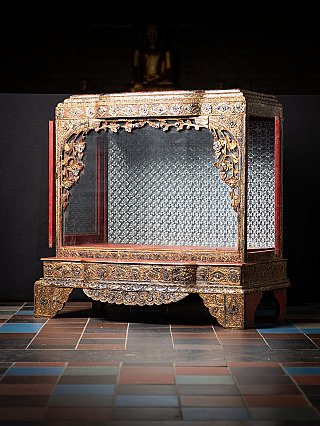 Burmese wooden temple shrine with left door open, showing side glazing and mirrored interior