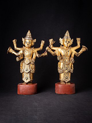 Burmese Nat statue pair, gilded wood with multiple arms, straight-on front view