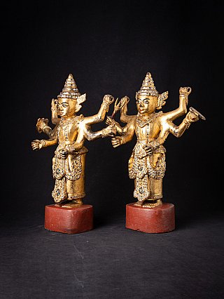 Burmese Nat statue pair in gilded wood, three-quarter view showing side arms