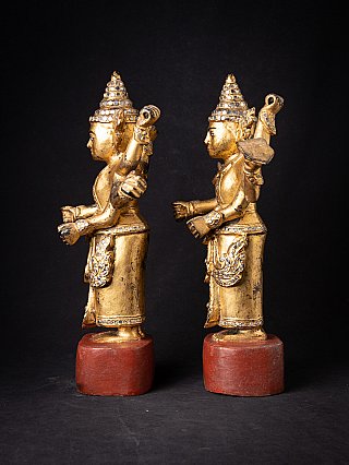 Burmese Nat statue pair, gilded wood, side profile with tall headdress and red bases