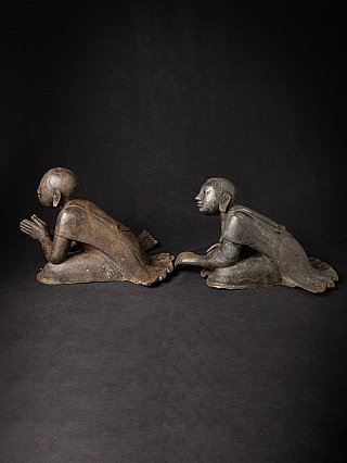 Pair of Burmese bronze monk statues seated, side profile showing robe drape