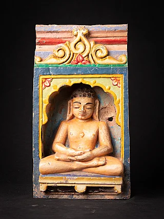 Antique Jain statue from India in a painted niche, seated with dhyana mudra, front view
