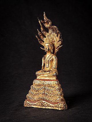 Thai bronze Buddha statue on Naga, seated, three-quarter right view