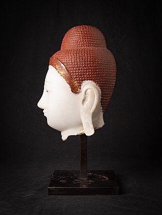 Marmeren Boeddhahoofd (Myanmar) in linker zijaanzicht, profiel van neus en oor met rode haartextuur