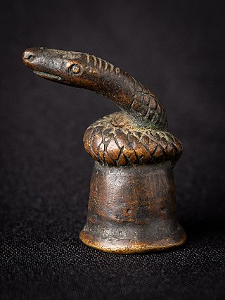 Bronze opium weight from Burma (Myanmar) with snake head and coiled body, three-quarter view
