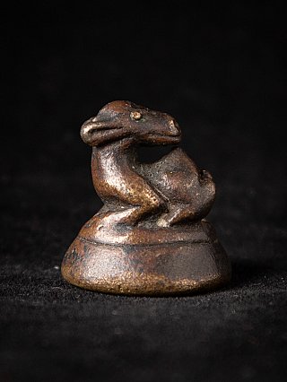 Antique Burmese bronze opium weight with animal figure on round base, side view