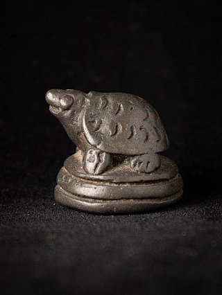 Burmese bronze opium weight, animal form on circular base in three-quarter view