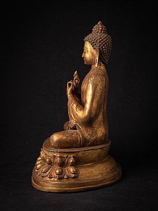 Nepali bronze Buddha statue seated on lotus base, left side profile