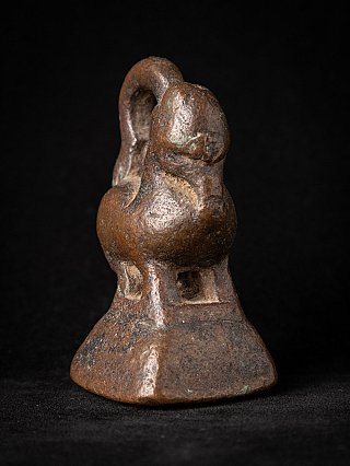 Bronze opium weight from Burma (Myanmar), three-quarter view showing rounded body and base opening
