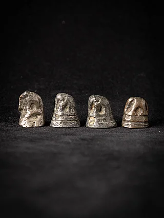 Set of four antique bronze opium weights from Burma (Myanmar), front view on black fabric