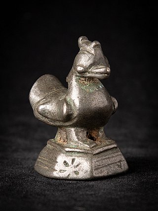 Bronze opium weight, three-quarter view highlighting the head and curved tail on the base