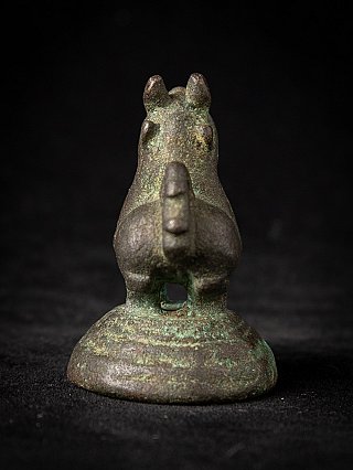 Antique bronze opium weight from Myanmar, rear view with raised tail on round base