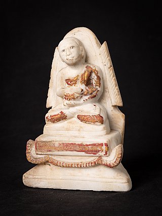Marble monk statue from Burma (Myanmar), seated, with worn red and gold paint, three-quarter view