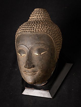 Bronzen Boeddhakop uit Thailand op sokkel, driekwartaanzicht van links