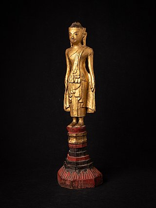 Stehende Buddha-Statue aus Holz aus Myanmar in Dreiviertelansicht, Gewandfalten und Sockel sichtbar