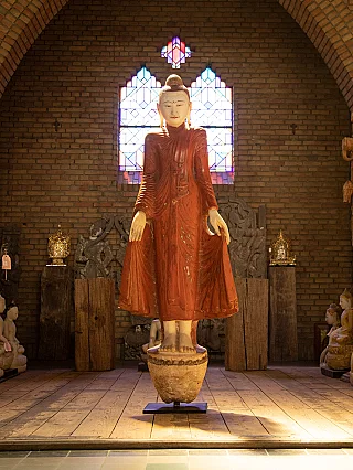 Stehende Marmor-Buddha-Statue aus Burma, frontal auf Sockel in Ausstellungsraum