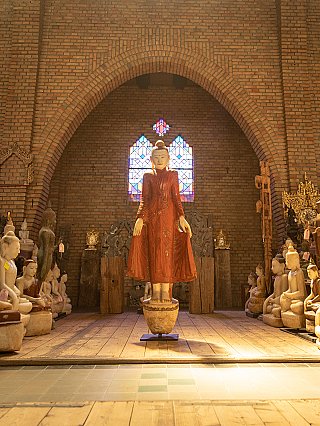 Burmese marble Buddha statue, full view in gallery setting under brick arch