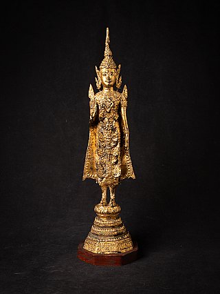 Thai bronze Buddha statue standing on a wooden base, full front view with Abhaya mudra