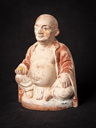 Happy Buddha-beeld uit India in driekwartaanzicht, met afbladderende verf op gezicht en torso